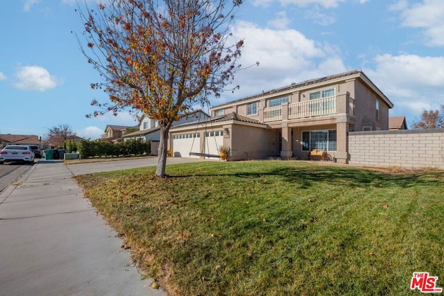 front of property featuring a balcony, a front yard, and a garage