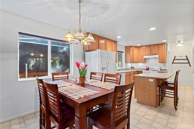 dining area featuring sink and an inviting chandelier