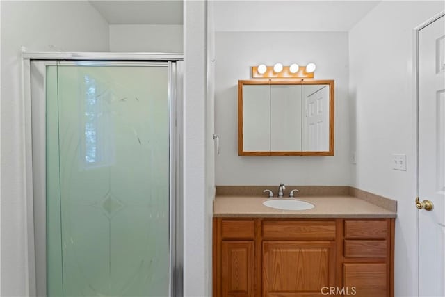 bathroom with vanity and a shower with door