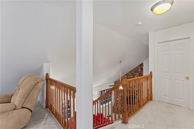 hall featuring light colored carpet and lofted ceiling