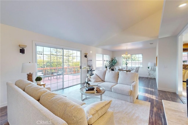 living room with vaulted ceiling, dark hardwood / wood-style floors, and a chandelier