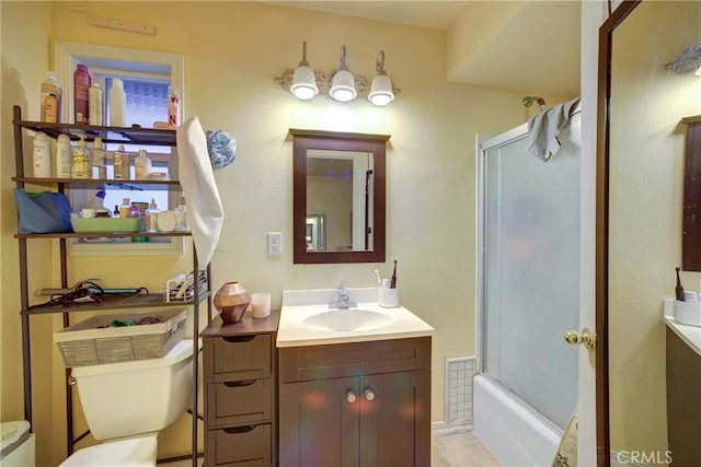 full bathroom featuring bath / shower combo with glass door, vanity, and toilet