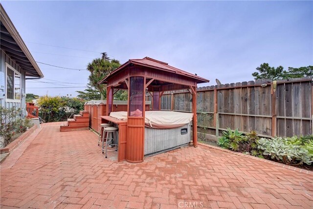 view of patio / terrace featuring a gazebo and a hot tub