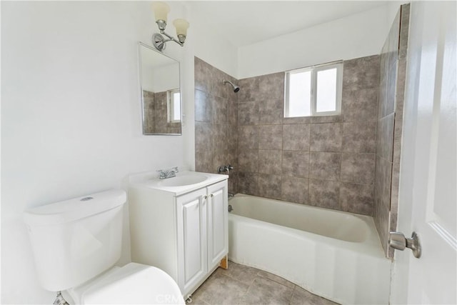 full bathroom featuring tile patterned flooring, vanity, tiled shower / bath combo, and toilet