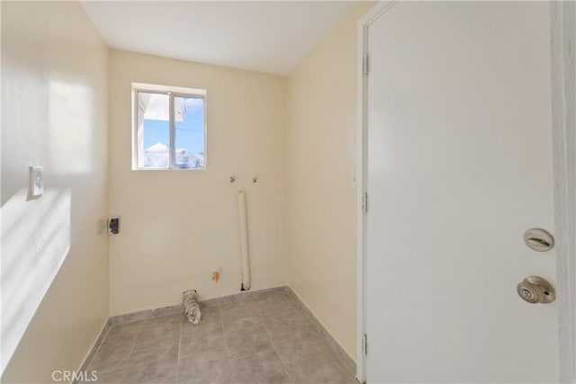 washroom featuring hookup for an electric dryer, light tile patterned floors, and hookup for a washing machine