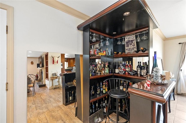 bar with crown molding and light hardwood / wood-style flooring