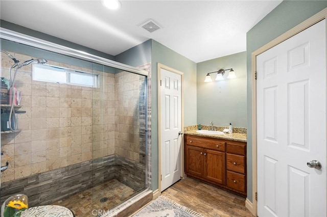 bathroom featuring vanity, wood-type flooring, and an enclosed shower