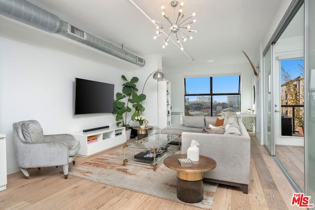 living room with an inviting chandelier and light wood-type flooring