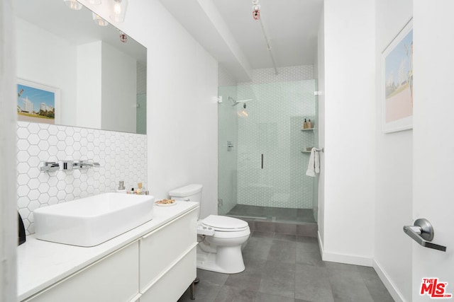 bathroom with tasteful backsplash, tile patterned floors, toilet, vanity, and a shower with shower door