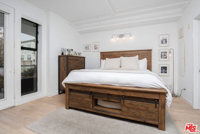 bedroom featuring light wood-type flooring and access to outside