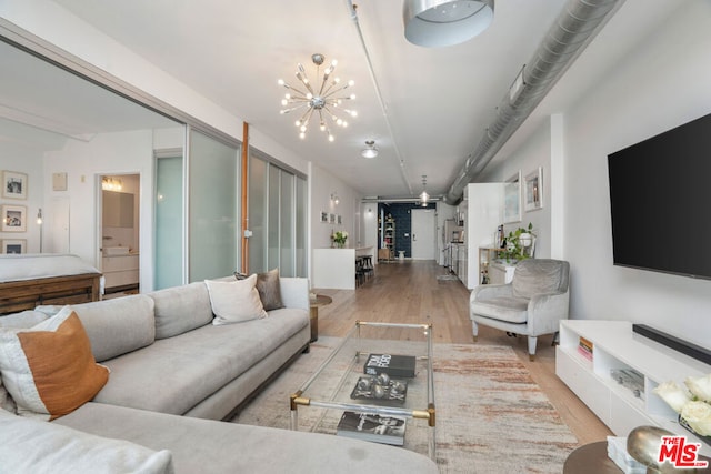 living room with a notable chandelier and light wood-type flooring