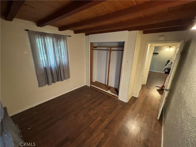 unfurnished bedroom with beam ceiling, wooden ceiling, dark wood-type flooring, and a closet