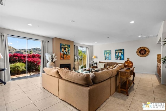 living room with a wealth of natural light, a mountain view, and light tile patterned floors