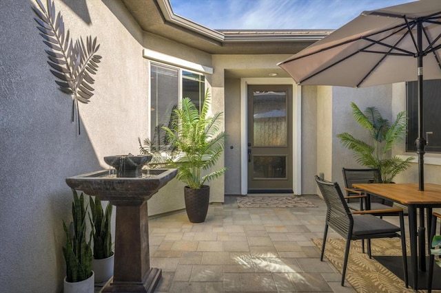 view of exterior entry featuring a patio area