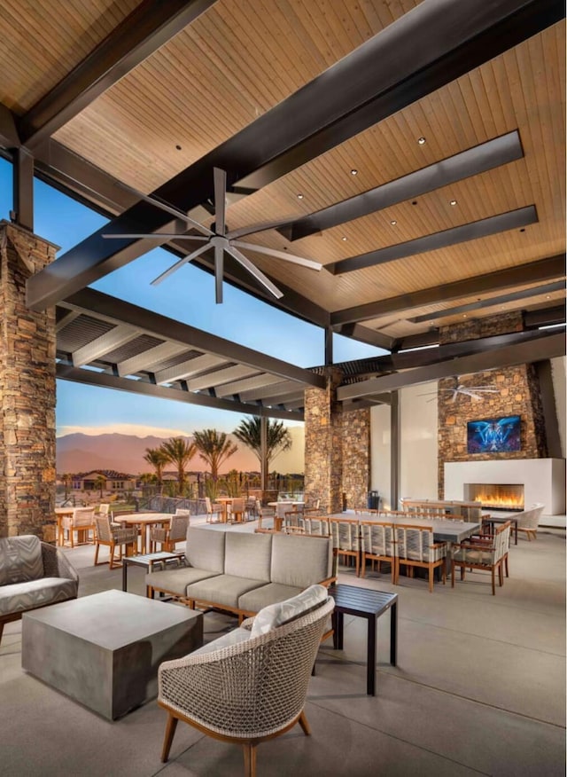 patio terrace at dusk with an outdoor living space with a fireplace