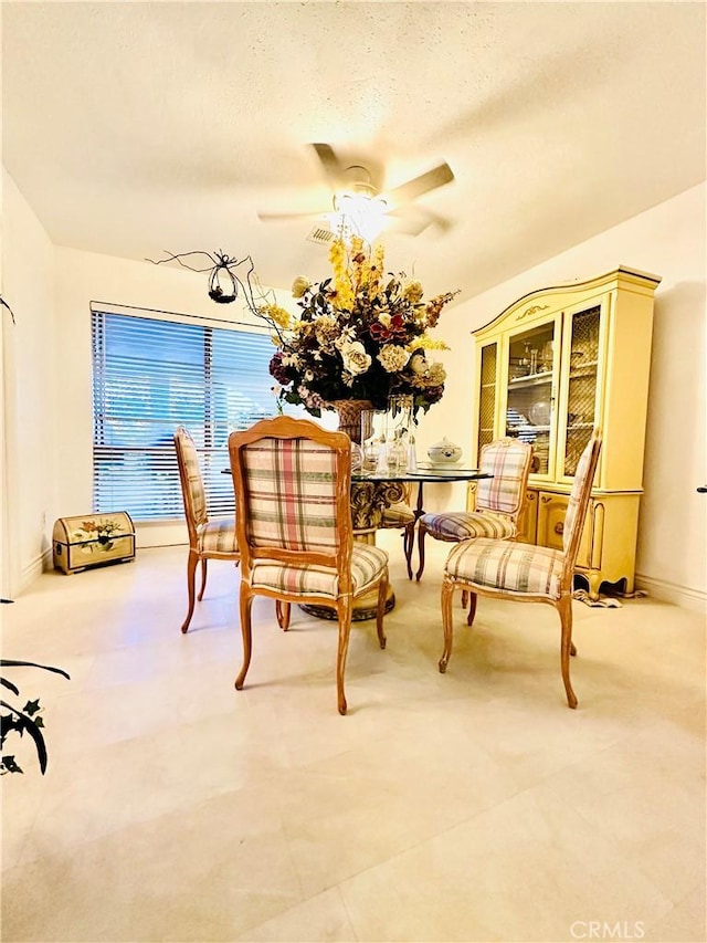 dining room with ceiling fan and a textured ceiling