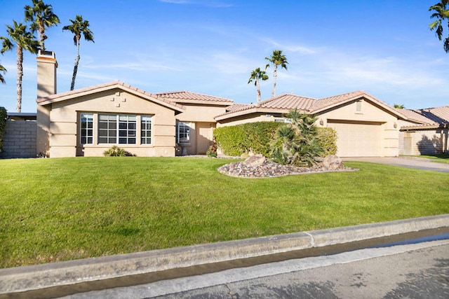 mediterranean / spanish house featuring a front yard and a garage