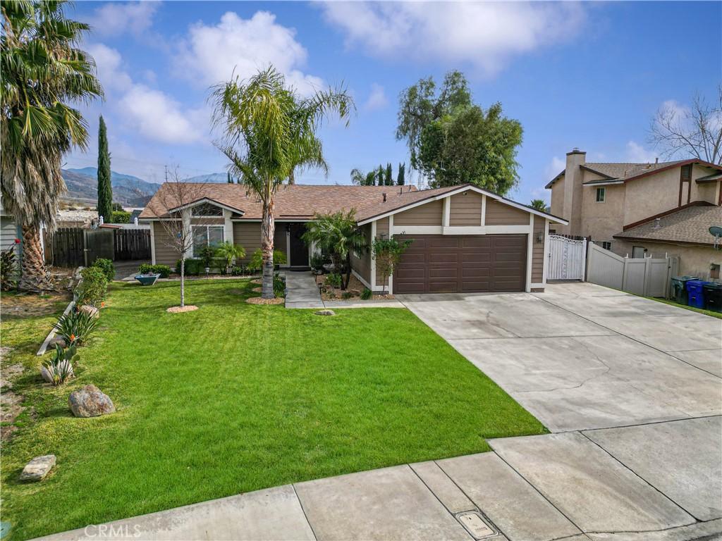 ranch-style house with a mountain view, a garage, and a front lawn