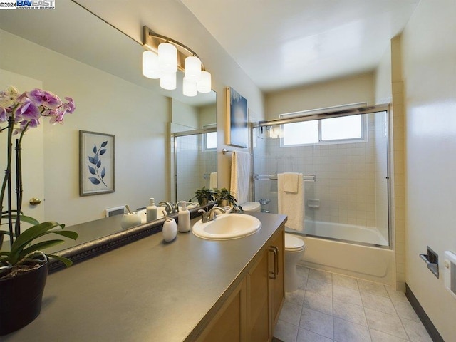 full bathroom with toilet, bath / shower combo with glass door, tile patterned flooring, and vanity