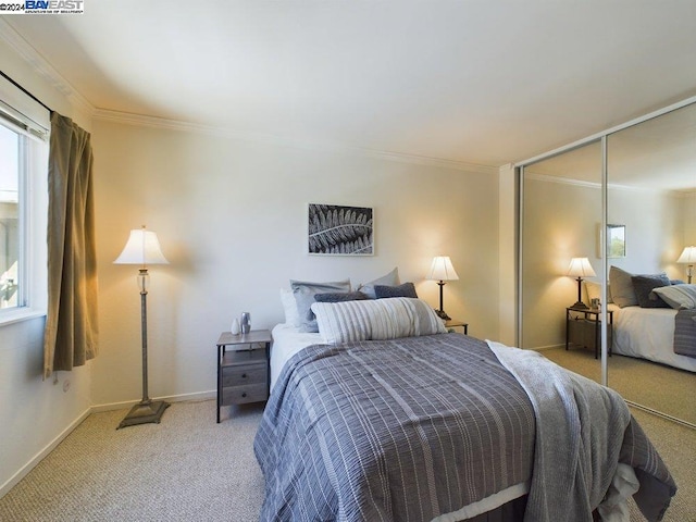 bedroom featuring ornamental molding, a closet, and light carpet