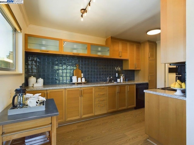 kitchen with backsplash, wood-type flooring, sink, black dishwasher, and light stone countertops