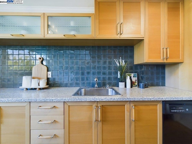 kitchen featuring light stone countertops, black dishwasher, tasteful backsplash, and sink