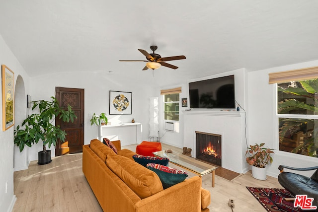 living room with ceiling fan, lofted ceiling, and light hardwood / wood-style flooring