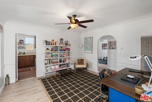 office area with light hardwood / wood-style flooring, ceiling fan, and sink