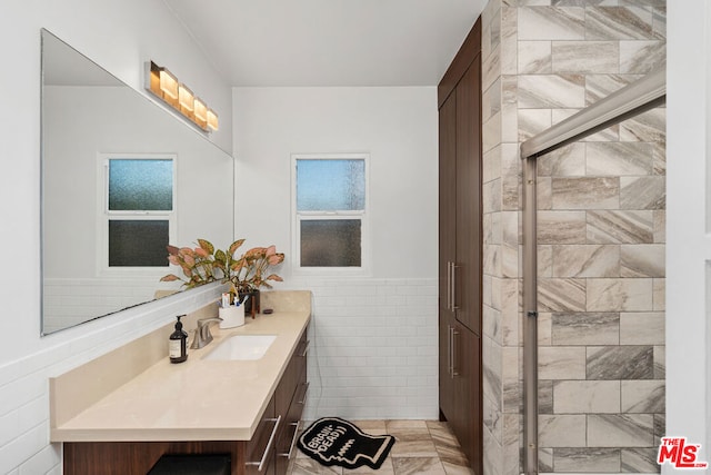 bathroom featuring vanity and tile walls