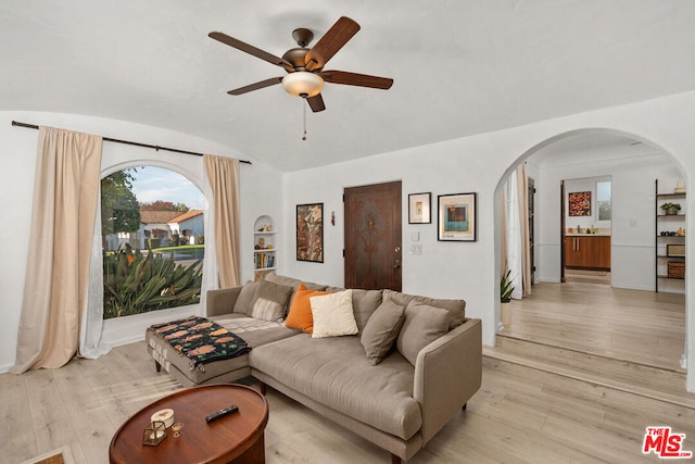 living room with light wood-type flooring, ceiling fan, and lofted ceiling