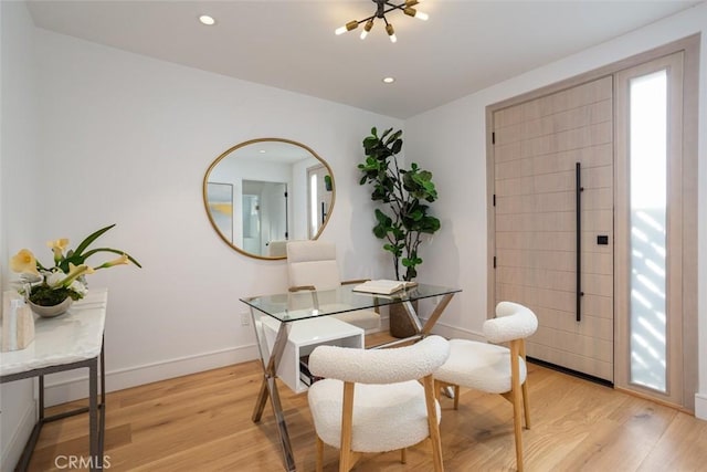 dining area featuring light hardwood / wood-style floors and an inviting chandelier