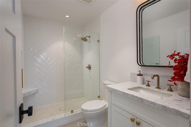 bathroom featuring tiled shower, vanity, and toilet