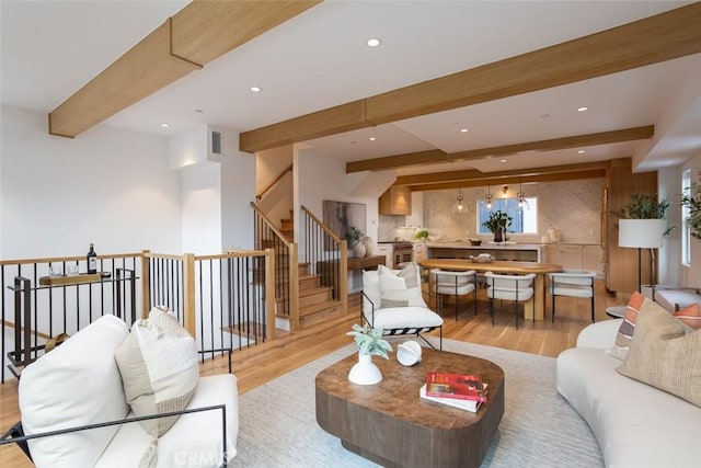 living room featuring beam ceiling and light wood-type flooring