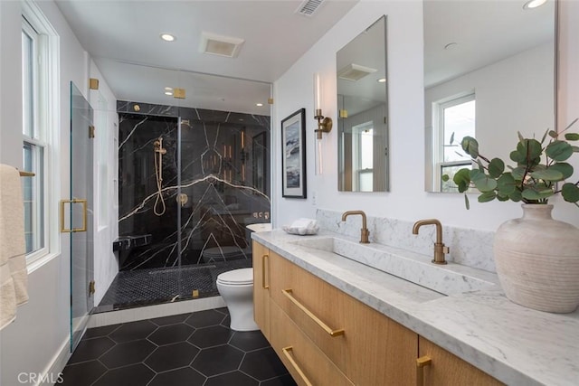 bathroom featuring tile patterned floors, vanity, a shower with shower door, and toilet