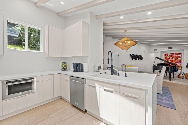 kitchen with kitchen peninsula, stainless steel appliances, vaulted ceiling with beams, light hardwood / wood-style floors, and hanging light fixtures