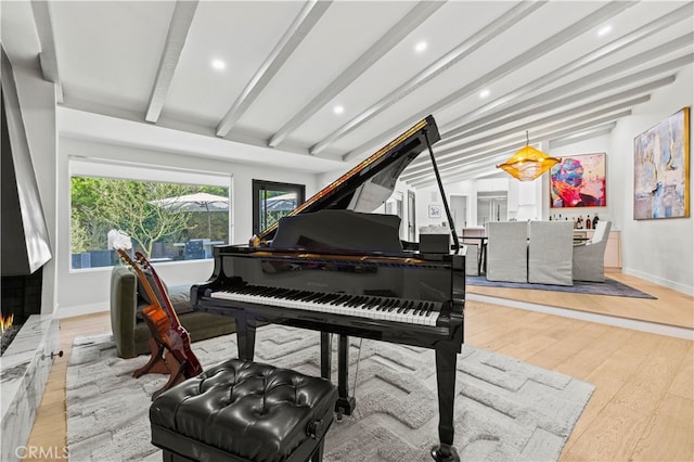 miscellaneous room with lofted ceiling with beams and light hardwood / wood-style floors