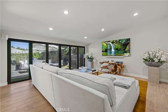 living room with light hardwood / wood-style floors and lofted ceiling