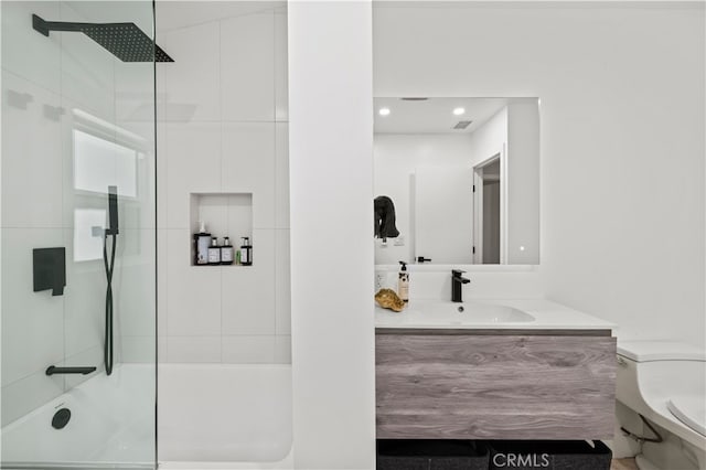 bathroom featuring vanity, toilet, and a tile shower