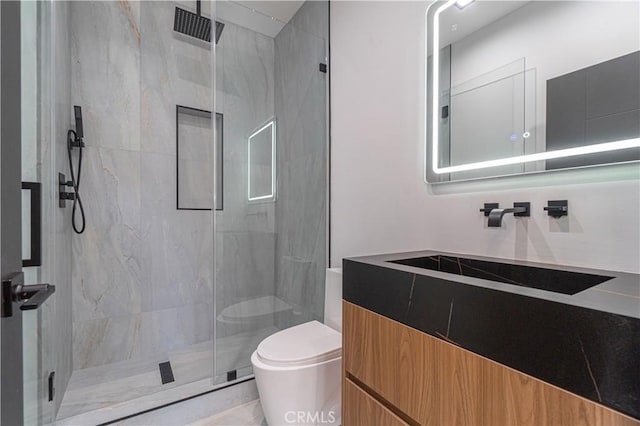 bathroom with vanity, toilet, and a shower with door