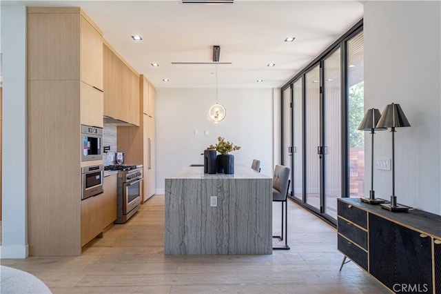 kitchen featuring stainless steel appliances, expansive windows, light hardwood / wood-style floors, decorative light fixtures, and light brown cabinetry