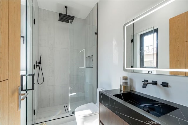 bathroom featuring vanity, an enclosed shower, and toilet