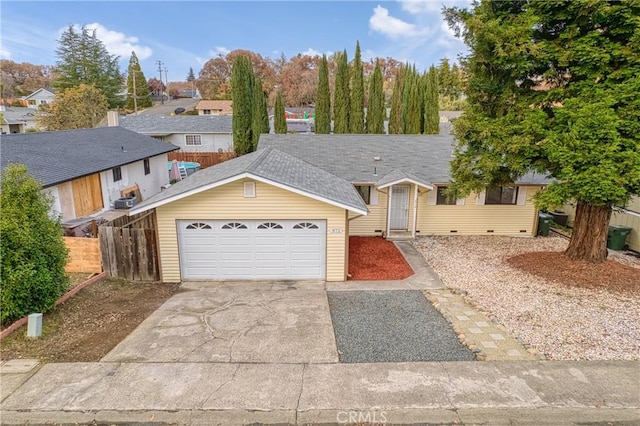 ranch-style home with a garage, concrete driveway, a shingled roof, and fence