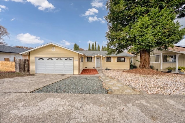 ranch-style house featuring a garage, fence, and driveway