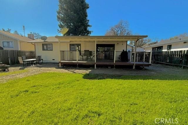 rear view of house featuring a yard, a deck, and fence