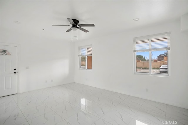 unfurnished room featuring a wealth of natural light and ceiling fan