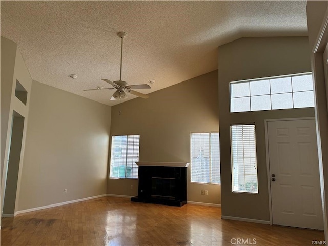 foyer entrance with hardwood / wood-style flooring, ceiling fan, lofted ceiling, and a textured ceiling