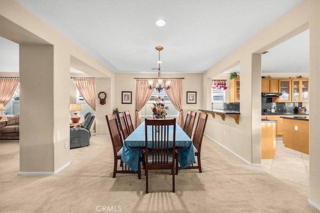 dining space with a notable chandelier and light carpet