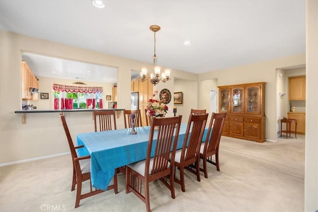 carpeted dining space with a chandelier