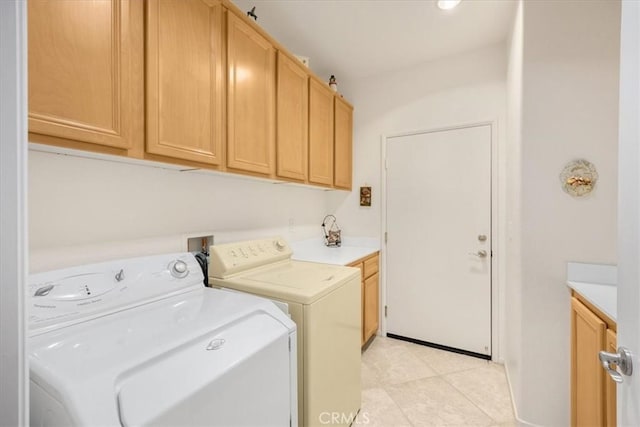 laundry room with cabinets, light tile patterned floors, and washer and dryer