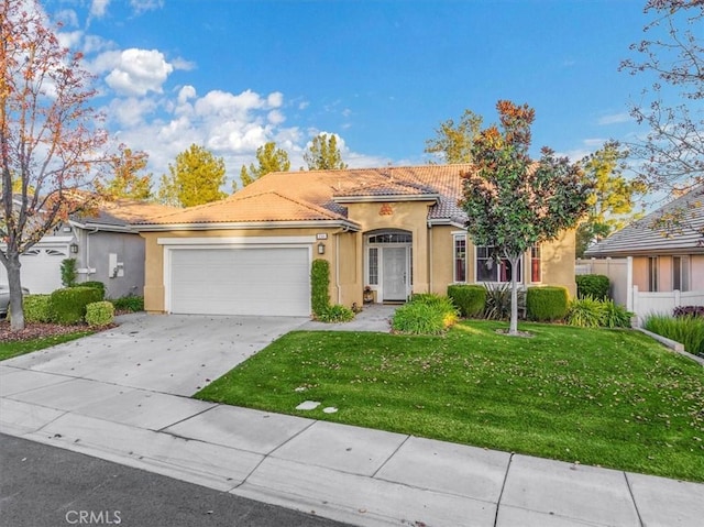 mediterranean / spanish house with a front yard and a garage